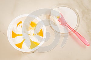 Fruit ice cream in a glass and spoon/fruit ice cream in glass and pink spoon on a white marble background, top view