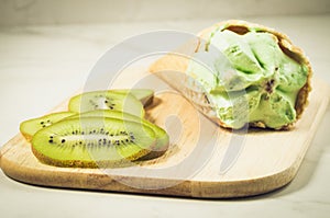 Fruit ice cream from a kiwi on a wooden tray/fruit ice cream from a kiwi on a wooden tray, selective focus