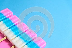 Fruit Ice cream stick , popsicle , ice pop or freezer pop with copyspace on blue and pink pastel background or texture