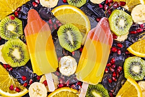 Fruit ice cream on stick with slices fruits on black