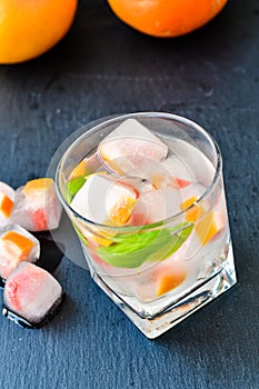 Fruit in ice cubes in water