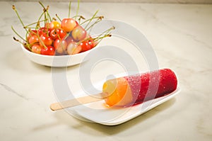 Fruit ice and sweet cherry in a white bowl/fruit ice and sweet cherry in a bowl on a marble background