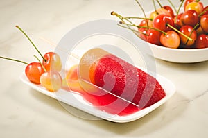 fruit ice and sweet cherry in a white bowl/fruit ice and sweet cherry in a bowl on a marble background. Selective focus