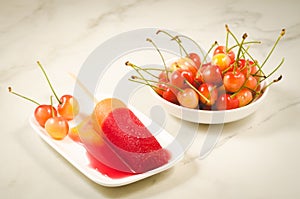 Fruit ice and sweet cherry in a white bowl/fruit ice and sweet cherry on a white marble background