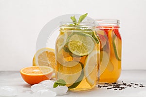 Fruit ice tea and ginger herbal ice tea with mint in a glass jar