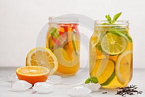 Fruit ice tea and ginger herbal ice tea with mint in a glass jar