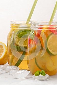 Fruit ice tea and ginger herbal ice tea with mint in a glass jar