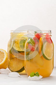 Fruit ice tea and ginger herbal ice tea with mint in a glass jar