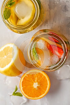 Fruit ice tea and ginger herbal ice tea with mint in a glass jar