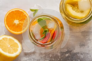 Fruit ice tea and ginger herbal ice tea with mint in a glass jar