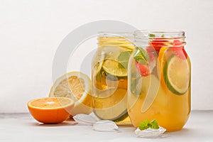 Fruit ice tea and ginger herbal ice tea with mint in a glass jar