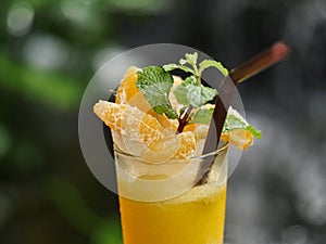 fruit juice, fruit smoothie, fruit juice, fruit juice in glass Placed on a rock near the waterfall