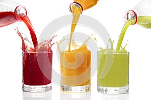 Fruit juices poured from bottles Kiwi, currants, orange