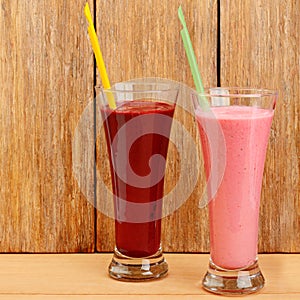 Fruit juices and smoothies made from strawberries, currants, raspberries on a wooden