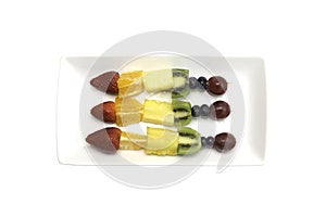 Fruit kebabs containing kiwi, grapes, strawberry, orange and pin