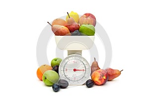Fruit and kitchen scales isolated on white background.