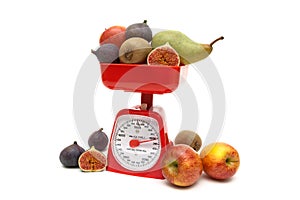 Fruit and kitchen scales isolated on white background