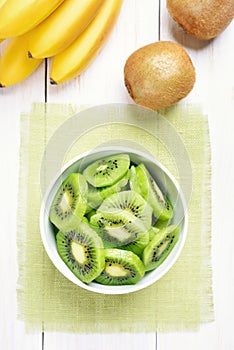 Fruit kiwi slices in bowl, top view