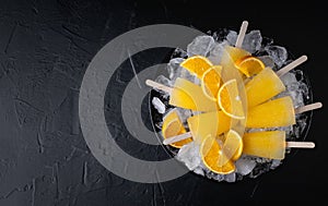 Fruit orange ice lolly and slices of orange. Top view. Copy space