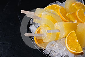 Fruit orange ice lolly and slices of orange. Top view. Copy space