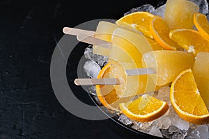 Fruit orange ice lolly and slices of orange. Top view. Copy space