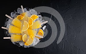 Fruit orange ice lolly and slices of orange. Top view. Copy space