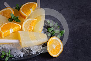 Fruit orange ice lolly and slices of orange.Top view. Copy space