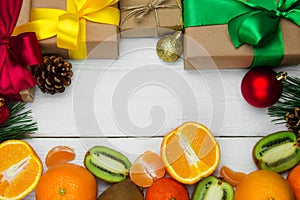 Fruit orange, kiwifruit and gift box with ribbon bow and red ball on white wooden retro background