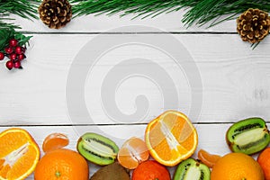 Fruit orange, tangerine and branch christmas tree cone on white wooden rustic background