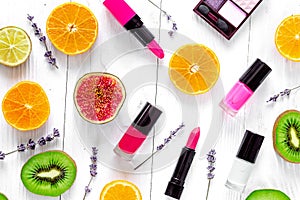 Fruit pattern with lipstick and nailpolish on white desk backgro photo