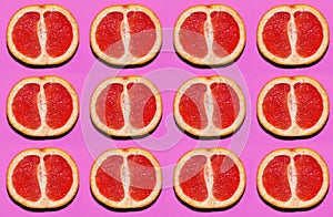 Fruit pattern. Slices of grapefruit on pink background