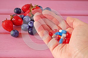 Fruit and pills, vitamin supplements with on pink  background. Healthy lifestyle, diet concept
