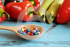 Fruit and pills, vitamin supplements with on wooden background. Healthy lifestyle, diet concept