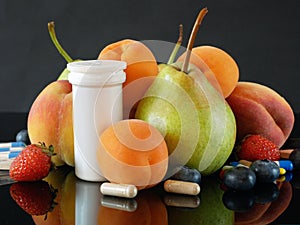 Fruit and pills, vitamin supplements with on wooden background. Healthy lifestyle, diet concept