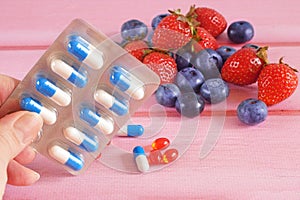 Fruit and pills, vitamin supplements with on wooden background. Healthy lifestyle, diet concept