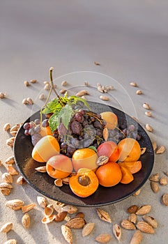 Fruit plate with grapes, apricot and almond.