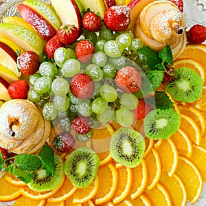 fruit plate with grapes, oranges, kiwis, apples and strawberries