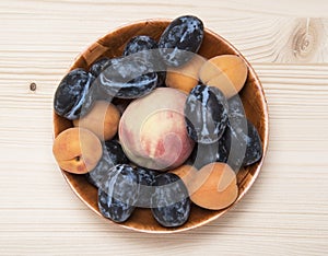 Fruit plate made from ripe plums, peaches and apricots