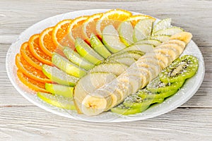 Fruit plate with oranges, bananas, apples, kiwi, pear