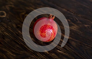 A fruit of pomegranate on a dark brown background.