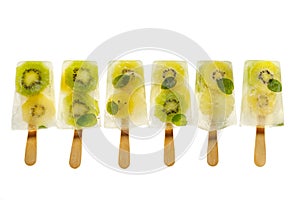 Fruit popsicles, homemade fruit ice lolly of various fruits; kiwi fruit and lime with the addition of fresh mint and citrus lemona