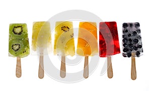 Fruit popsicles, homemade fruit ice lolly of various fruits; mandarins, limes, kiwi, blueberries and raspberries with the addition