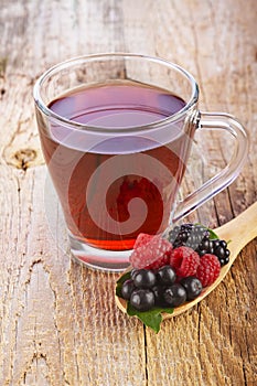 Fruit red tea with wild berries in wooden spoon