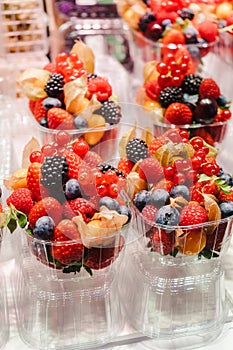 Fruit Salad arranged in plastic cups on a market stall with small fork inside, takeaway snack