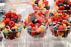 Fruit Salad arranged in plastic cups on a market stall with small fork inside, takeaway snack