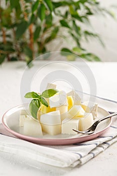 Fruit salad with cheese. Mango, melon with cheese and Basil