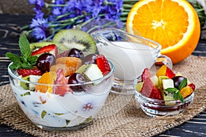 Fruit salad closeup with berries, yogurt and granola in a glass