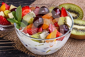 Fruit salad closeup with berries, yogurt and granola in a glass