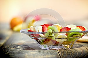Fruit salad in glass bowl closeup, healthy delicious vegan food