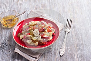Fruit salad of grapes, bananas and apples with poppy seeds and honey